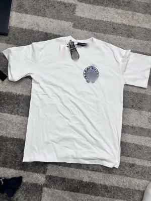 Vit Chrome Herts t-shirt med tryck - Säljer en vit t-shirt från Chrome Herts med svart tryck på bröstet och stort motiv på ryggen. Klassisk passform och rund hals. Tillverkad i mjuk bomull, perfekt för en avslappnad och stilren look. Storlek small men är stor i storlek⚠️