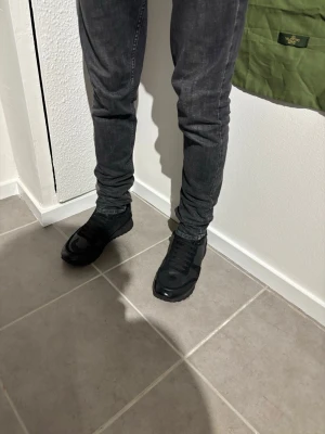 Valentino rockrunners  - Säljer ett par svarta sneakers med snygga detaljer i både mesh och mocka. Skorna har en klassisk låg siluett och svarta skosnören. Perfekta för dig som gillar en clean och stilren look till vardagsjeansen.
