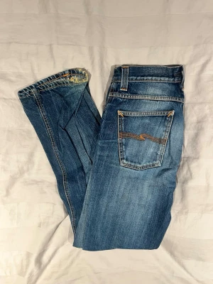  nudie jeans  - Ljusblåa nudie jeans! Storlek 32/34! Modell slim Jim! Material 100% bomull! Skick: Bra! De finns några fläckar och slitningar som är med på bilderna där av priset! Pris 399! Kontakta om frågor eller fler bilder! 
