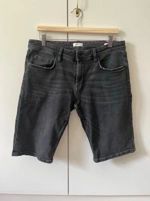 Svarta jeansshorts från Esprit strl 32 - Säljer ett par svarta jeansshorts från Esprit med klassisk femficksdesign. Shortsen har raka ben och normal passform.  Material 99% bomull, 1% elastan.  Storlek 32.