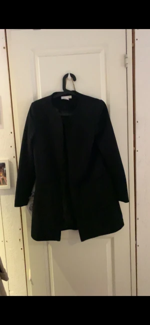 Svart kappa från H&M - Säljer en svart kappa från H&M, perfekt till hösten och våren, passar perfekt till allting och är i bra skick