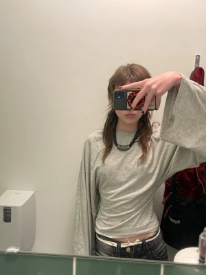 Grå topp - En grå topp fån nelly med vida armar. Den är tight vid midjan och har vida armar. Storlek xs. Råkade köpa två stycken, så den jag säljer är helt ny, inte öppnad ur paketet. Skriv för fler bilder och mått💜