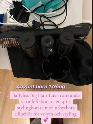 BaByliss Big Hair Luxe varmluftsborste - BaByliss Big Hair Luxe är en svart 4-i-1 roterande varmluftsborste med utbytbara borsthuvuden för volym och styling. Inkluderar flera tillbehör och en hållare, perfekt för att skapa olika frisyrer.