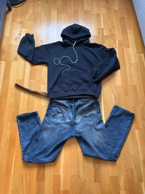 Mörkblå hoodie - En stilren mörkblå hoodie med klassisk huva och stor magficka framtill. Hoodien har ribbade muddar vid ärmslut och nederkant. Perfekt för en avslappnad stil.