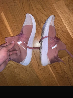 Rosa höga sneakers med vita detaljer - Säljer ett par snygga rosa sneakers med högt skaft och vita detaljer på sidan. Skorna har en chunky vit sula och matchande rosa skosnören. Ovandelen är i textilmaterial och designen är modern och clean. Tränings skor nypris 2000 kronor märke arrk Danmark 