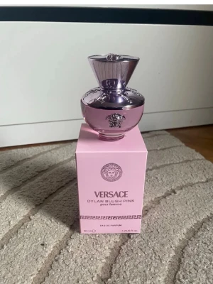 Versace Dylan Blush Pink parfym 50 ml - Versace Dylan Blush Pink pour femme är en elegant parfym i en lyxig, ljusrosa flaska med silverdetaljer och Versaces ikoniska Medusa-huvud. Flaskan har en unik, rundad form och kommer i en matchande rosa kartong. Perfekt för dig som gillar exklusiva dofter. Bara testat 1 sprut. Har online kvitto som jag köp för ca 1200kr för nån vecka