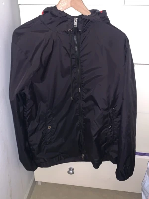 Svart vindjacka från Moncler - säljer en moncler windbreaker  i storlek 2 nfc scan funkar och industritag finns, 2 taggar på dragkedjan är borta men det går och dra upp helt utan konstigheter