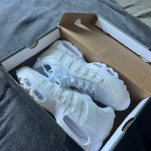 Vita sneakers - Fräscha helvita Nike Air Max sneakers med klassisk chunky sula och meshdetaljer. Skorna har en sportig vibe med tydliga luftbubblor i sulan och diskret Nike-logga på sidan. Perfekta för dig som gillar en clean och modern look.  det blir billigare via cash 