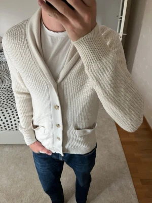 Krämvit cardigan från Mango - Säljer en väldigt snyggt stickad cardigan från Mango i ett mycket bra skick. Tröjan är i storleken S men sitter som en M! 😁✌🏼——————————————————————————                                                                      📐| Storlek: S (Sitter som M)                                                           👖| Märke: Mango                                                  🔎| Skick: Mycket Fint                                                      ✍🏻| Skriv om du har några frågor