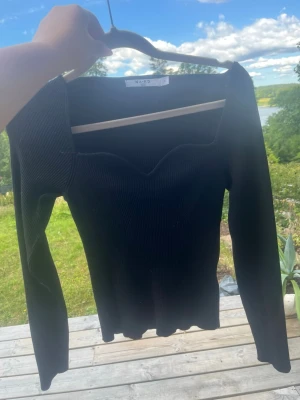 Svart ribbad topp från NA-KD - Säljer en svart långärmad topp från NA-KD med ribbad struktur, väldigt bekväm och stretchig, den är i storlek S men jag skulle säga att den är lite i mellan S och m då den är väldigt stretchiga 