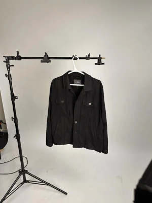 Svart overshirt Dressman - Shysst overshirt från dressman, det var min mainjacka ett tag och den var snygg som fan och passade med allting, den saknar tyvärr en knapp men det finns extra som man kan sy på
