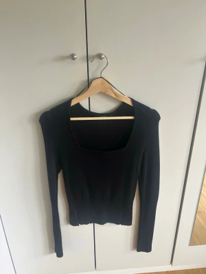 Svart ribbad långärmad topp - Säljer en svart ribbad topp med lång ärm och fyrkantig urringning. Toppen är tight i modellen och har en croppad passform som passar perfekt till höga jeans eller kjol. Enkel men stilren design som funkar till mycket💋