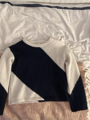 Svartvit stickad tröja Gina Tricot - Säljer en snygg stickad tröja från Gina Tricot i storlek 134/140. Tröjan har ett coolt diagonalt mönster i svart och vitt, rund halsringning och långa ärmar. Perfekt för dig som gillar en stilren men trendig look. våga skicka bud!💕