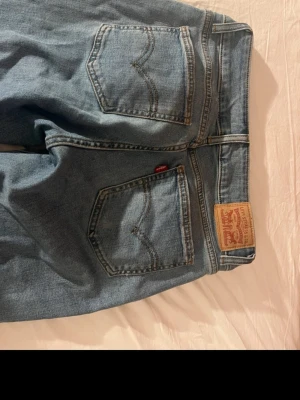 Levi's ljusblå utsvängda jeans - Säljer ett par ljusblå Levi's jeans med utsvängda ben och rå kant nertill. Klassisk femficksmodell med Levi's patch bak i midjan och röd etikett på bakfickan. Jeansen är i ett mjukt denimtyg och har en avslappnad vintage vibe. Skulle säga storlek S-M. De har inga defekter, skriv vid eventuella frågor💕💕