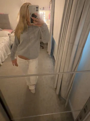 Grå lyle and scott hoodie - Säljer en ljusgrå lyle and scott hoodie med huva och dragsnören. Hoodien har en avslappnad passform och är perfekt för en chill look. 