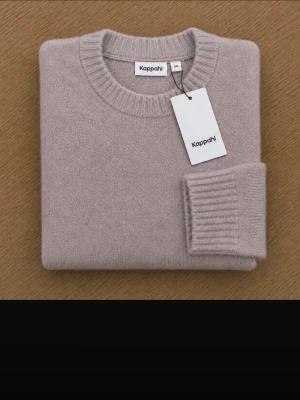 Beige stickad tröja från Kappahl helt ny med etikett - strl XXL - Mjuk och stilren beige stickad tröja från Kappahl med rund halsringning och ribbade muddar vid ärmslut och nederkant. Perfekt oversized passform för en avslappnad look. Tröjan är i ett skönt material som känns lyxigt mot huden. Helt ny med etikett, strl XXL