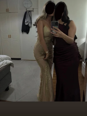 Vinröd långklänning oneshoulder - Elegant vinröd långklänning i glansigt material med oneshoulder-design och draperad detalj över höften. Klänningen har en figurnära passform och är perfekt för bal eller festliga tillfällen. Snygg och stilren look som verkligen sticker ut. Använt några timmar 