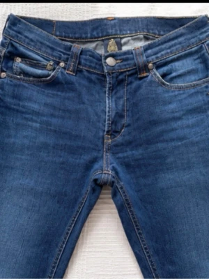 DonDup jeans - Snygga mörkblå slim fit jeans med klassisk femficksdesign och kontrastsömmar. Jeansen har normal midja och raka ben. Tillverkade i stretchigt denimtyg för extra komfort och rörelsefrihet. Perfekta till en avslappnad och trendig look.