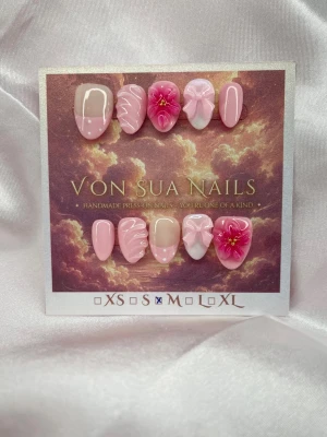 Peonia (M);ExtraShortAlmond  - Snygga handgjorda press-on naglar i olika rosa nyanser med 3D-blommor, swirl-mönster och fransk design. Mix av glansiga och matta ytor, vissa naglar har detaljer i vitt och guld. Extra krot mandel form och unikt konstnärligt uttryck. Perfekt för dig som vill sticka ut.M: 16 mm, 12 mm, 12,5 mm, 11,5 mm, 10 mm