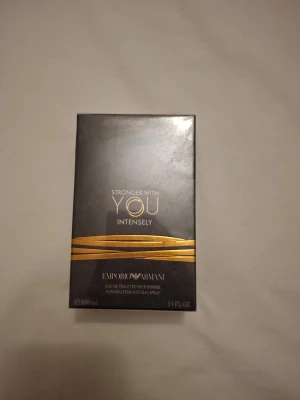 Emporio Armani Stronger With You Intensely - Emporio Armani Stronger With You Intensely är en herrparfym i en elegant svart förpackning med guldiga detaljer. Doften är en eau de toilette och flaskan rymmer 100 ml. Förpackningen har en lyxig och modern design som passar perfekt för dig som gillar exklusiva dofter. !oöpnnad!