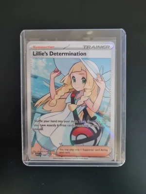Pokémonkort Lillie's Determination - Säljer ett Pokémonkort med motivet Lillie's Determination. Kortet har färgglad design med anime-inspirerad illustration och text på engelska. Kortet är av papper och plast och ligger i ett genomskinligt skyddsfodral.