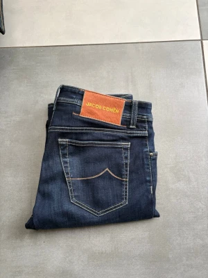 Jacob Cohën Jeans herr  - Säljer nu ett par riktigt sköna Jacob Cohën Jeans för herr! 🌟 Storlek - 32/32 | Otroligt skönt material! Modell: Bard✅ Midjevidd- ca 41cm, total längd- ca 108cm.  Jeansen är i 9,5/10 skick och är självklart 100% autentiska och äkta. 🚚Alltid frakt inom 24h!🚚