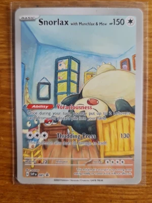Pokémonkort Snorlax SVP 085 Promo - Unikt Pokémonkort med Snorlax, Munchlax & Mew från Scarlet & Violet-serien, promo SVP 085. Kortet har färgglad illustration och är tillverkat i laminerad papp. Perfekt för samlare eller Pokémon TCG-spelare.