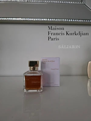 Maison Francis Kurkdjian Grand Soir 70 ml - Exklusiv parfym i elegant glasflaska med guldigt lock från Maison Francis Kurkdjian. Doften Grand Soir kommer i en fyrkantig flaska med bärnstensfärgad vätska och matchande kartong. Perfekt för dig som gillar lyxiga och sofistikerade dofter. 