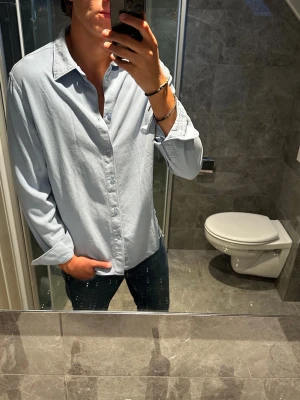 Ljusblå skjorta från J.Lindeberg - Snygg ljusblå skjorta från J.Lindeberg. Skjortan ska vara i storlek S men sitter mer som en M/L. I övrigt riktigt bra skick o inga defekter. Jag på bilden är 188cm för referens. Hör av er vid vidare frågor och funderingar;)