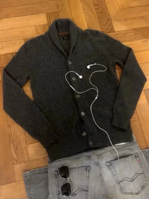 Massimo dutti kofta - Mysig mörkgrå kofta med sjalkrage och stora knappar framtill. Tyvärr lite trasig på en av knapparna men inget som påvärkar på nått sätt o lätt att fixa annars jättebra skick!