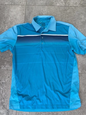 Retro Golfpiké - Retro Golfpiké från Adidas som är i en fin blå färg. Den är lite stor i storleken så funkar nog för L också. Nackdel är att det är några fläckar som man ser om man kolllar riktigt noga