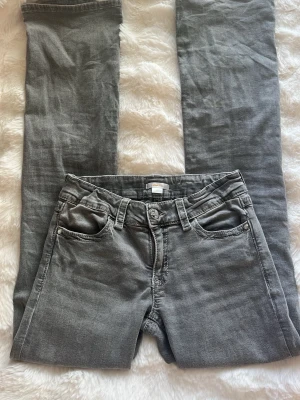 Grå jeans från Gina Tricot - Bootcut jeans från Gina tricot young. Ena knappen är borta och några trådar är lite lösa men annars i mycket bra skick.
