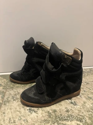 Svarta höga sneakers med kilklack - Ett par Isabel marang skor/stövlar som är drygt 2-3 år gammal men fortfarande väldigt bra skick. Finns box, dustbag och kvitto! Storlek 38 men passar mig som har 39