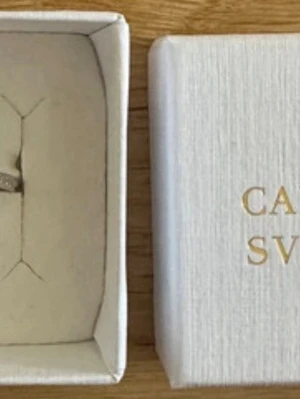Caroline Svedbom ring  - Caroline Svedbom silverfärgad ring med ett snäckskalsmotiv och blå glittrande sten. Ringen har en öppen design med ytterligare en liten blå sten på andra sidan. Perfekt för dig som gillar havsinspirerade accessoarer och vill sticka ut. Ny