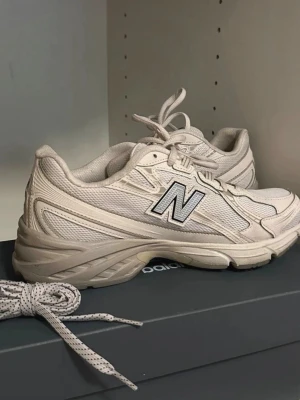 Beige New Balance sneakers - Snygga beige sneakers från New Balance. Skorna har mesh- och syntetpaneler för bra andningsförmåga och komfort. Tjock sula för extra stöd och en sportig look. Perfekta för dig som gillar stilrena och neutrala färger. Använda ca 3 gånger, allt på bilden ingår