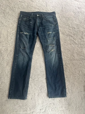 Levis 505 - Säljer ett par snygga Levis 505 i en mörkblå färg, snygga slitningar och passar till allt. Hör av er mig funderingar 