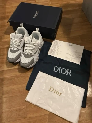 Vita och grå zara sneakers - Säljer ett par snygga  sneakers i vitt och grått med chunky sula och meshdetaljer. Skorna har en modern siluett, vita skosnören och reflekterande detaljer. Perfekta för dig som vill ha en exklusiv och trendig look.