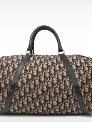 Dior 48h väska  - Snygg weekendbag i beige och svart med ett klassiskt monogrammönster. Väskan har svarta handtag och detaljer i läderimitation samt dragkedja upptill. Perfekt storlek för kortare resor och har en tidlös look som sticker ut.jättebra skick. Så fin och får plats med mängder.