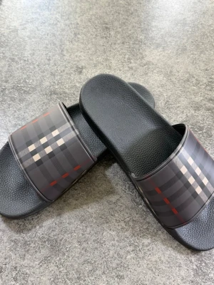 Svarta Burberry tofflor -  Säljer ett par svart Burberry tofflor storlek 43