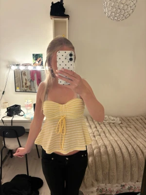 Gul och vit randig bandeau topp - Söt bandeau topp i gult och vitt med ränder och knyt framtill. Toppen har en utsvängd passform och är ärmlös, perfekt för varma dagar. Materialet känns mjukt och stretchigt, vilket gör den bekväm att bära. Supersnygg till både jeans och kjol! Den är från shein!!!