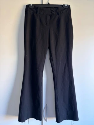 Lågmidjade kostymbyxor  - Svarta lågmidjade bootcut kostymbyxor från bikbok med snyggt knäppe, köpte för länge sen så tror ej modellen finns kvar 💞 stretchiga och kan passa en S. Obs! Avklippta!! Innerbenslängd: ca 68-70 cm