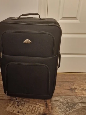 Svart mjuk resväska med fickor - Snygg svart resväska i mjukt tygmaterial med flera dragkedjeförsedda ytterfickor och praktiskt bärhandtag upptill. Väskan har en stilren design och är perfekt för resor när du vill ha med dig mycket packning.
