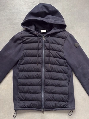 Moncler Cardigan  - Väldigt bra skick generellt, har endast två skador på framsidan som sytts ihop och knappt syns, till och med svåra att hitta på första bilden. Blackbadge Moncler.