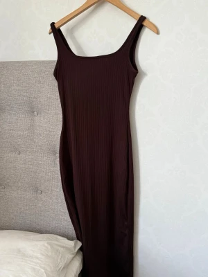 Brun ribbad långklänning från SHEIN - Säljer en brun ribbad långklänning från SHEIN i storlek XXS Petite. Klänningen har smala axelband, rak halsringning och är figurnära i modellen. Perfekt för dig som gillar en enkel och stilren look.