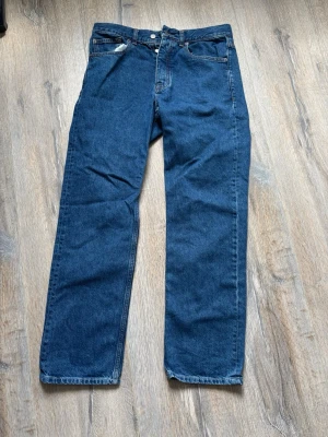 Mörkblå raka jeans - Säljer ett par klassiska mörkblå jeans med rak passform och fem fickor. Jeansen har hög midja och stängs med knapp och dragkedja. Perfekta till en avslappnad stil och funkar året runt.