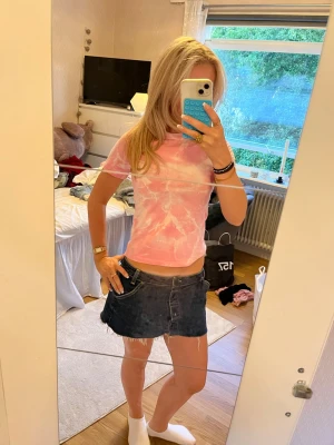 Rosa tie-dye t-shirt i bomull - Säljer en kortärmad rosa och vit tie-dye t-shirt i mjuk bomull. Den är tie dyead själv hemma. T-shirten har en klassisk passform och rund halsringning. Perfekt för dig som gillar färg och vill ha en chill vibe på outfiten.
