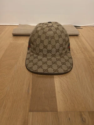 Beige keps med GG-mönster  - Använd 3-4 gånger, se defekt på bild inget som märks kommer med dustbag 