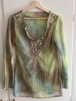 Whimsical blus - Whimsical blus med vida armar, nytvättad och ej använd av mig. Köpt secondhand. Storlek 40 men känns mer som 36-38. Ska finnas ett band/skärp (se bild 6) men saknades vid köp.