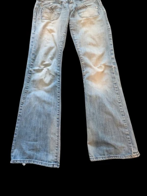 Ljusblå vintage bootcut jeans hm - Säljer ett par ljusblå bootcut jeans med slitningar på benen. Vintage hm med storlek 29, MEN är sydda på både sidor av midjan för att passa en S, annars skulle den passa M (det går enkelt öppna sydda platsen). Skriv om du vill mer info 💕