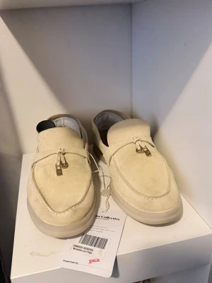 Loro piana ÄKTA loafers - Äkta,  Storlek 39,5 Köpta via Vestiaire Collective Mockan har behållit sin mjuka textur och nyansen varierar naturligt. Lätta tecken på användning syns, särskilt vid tårna och på sidorna. Det finns visst slitage på in- och yttersulor, samt normalt användningsslitage på klackarna och sulkanterna. Jag säljer dem eftersom de var för stora för mig i hälen. Vänligen kontrollera tillgängligheten innan köp, då skorna även ligger ute till försäljning på andra plattformar.